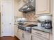 Kitchen features stainless steel range hood, gas cooktop, granite countertops, and tile backsplash at 2525 Vaccaro Dr, Sarasota, FL 34231