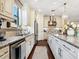 Gourmet kitchen with stainless steel appliances, granite countertops, white cabinetry, and hardwood floors at 2525 Vaccaro Dr, Sarasota, FL 34231