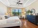 Primary bedroom features hardwood floors, large windows, tray ceiling, ceiling fan, and neutral paint at 2525 Vaccaro Dr, Sarasota, FL 34231