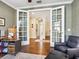 View of office opening to the bright hallway through glass-paneled French doors at 2525 Vaccaro Dr, Sarasota, FL 34231