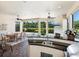 Spacious outdoor living area featuring a dining set, fireplace, outdoor kitchen and serene backyard views at 2525 Vaccaro Dr, Sarasota, FL 34231