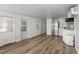 Open floor plan with wood laminate flooring, complemented by a bright white kitchen at 2601 Gulf N Dr # 317, Bradenton Beach, FL 34217