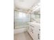 Bright bathroom with marble tile walls, modern vanity, and sliding glass shower doors at 301 89Th Ne Ave, St Petersburg, FL 33702