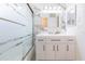 Bathroom with marble tile walls, modern vanity with black hardware and bathtub with sliding glass door at 301 89Th Ne Ave, St Petersburg, FL 33702