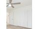 Bedroom features wood-look floors, modern ceiling fan and closet with white louvered doors at 301 89Th Ne Ave, St Petersburg, FL 33702