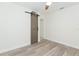 This light and airy bedroom features a decorative sliding barn door and wood-look flooring at 301 89Th Ne Ave, St Petersburg, FL 33702