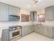 Kitchen with stainless steel appliances, custom cabinets, gorgeous counter tops, and neutral backsplash at 301 89Th Ne Ave, St Petersburg, FL 33702