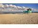 Idyllic beach scene with a lifeguard station overlooking the tranquil ocean under a partly cloudy sky at 340 Base E Ave # 314, Venice, FL 34285