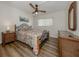 Cozy bedroom with wood-look flooring, decorative linens, a wooden nightstand and stylish ceiling fan at 340 Base E Ave # 314, Venice, FL 34285