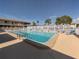 Community pool surrounded by a white fence and lounge chairs on a sunny day at 340 Base E Ave # 314, Venice, FL 34285