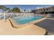 Community pool surrounded by a white fence and lounge chairs on a sunny day at 340 Base E Ave # 314, Venice, FL 34285