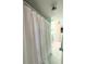 Bright bathroom featuring a white shower curtain, white tile floor, and updated light fixture at 3559 Lake Bayshore Dr # J-204, Bradenton, FL 34205