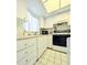 The kitchen is equipped with white cabinetry and includes a microwave, range, and a window for natural light at 3559 Lake Bayshore Dr # J-204, Bradenton, FL 34205