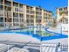 Community pool with lounge chairs and a fence in front of a low-rise apartment complex at 3559 Lake Bayshore Dr # J-204, Bradenton, FL 34205