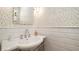 Classic bathroom with white tiled walls, pedestal sink, and decorative mirror at 403 75Th St, Holmes Beach, FL 34217