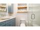 Modern bathroom with stylish blue cabinetry, textured walls, and a glass-enclosed shower, creating a spa-like experience at 403 75Th St, Holmes Beach, FL 34217