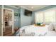 Comfortable bedroom with blue walls, a flat-screen TV, and a view into an adjacent room, offering a relaxing retreat at 403 75Th St, Holmes Beach, FL 34217