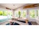 Bright dining area featuring a rustic wood table, bench seating, and sliding glass doors leading to the pool area at 403 75Th St, Holmes Beach, FL 34217
