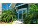 A cozy entrance showcases double glass doors and blue accents surrounded by lush tropical plants at 403 75Th St, Holmes Beach, FL 34217