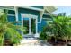 A cozy entrance showcases double glass doors and blue accents surrounded by lush tropical plants at 403 75Th St, Holmes Beach, FL 34217