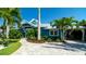 Charming coastal home with a well-manicured lawn, lush landscaping, and a welcoming paver walkway at 403 75Th St, Holmes Beach, FL 34217
