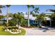 Charming coastal home with lush landscaping, a paver driveway, and a well-manicured lawn at 403 75Th St, Holmes Beach, FL 34217