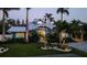 Inviting coastal home showcasing professional landscaping and a paver driveway leading to a covered area at 403 75Th St, Holmes Beach, FL 34217