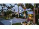 Beautiful coastal home with lush tropical landscaping, a metal roof, and a paver driveway leading to covered parking at 403 75Th St, Holmes Beach, FL 34217