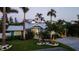 Lovely blue coastal home featuring mature palms, verdant lawn and landscaping, and a light-colored paved driveway at 403 75Th St, Holmes Beach, FL 34217