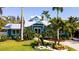Charming blue home boasts lush landscaping and a well-manicured lawn, creating a welcoming curb appeal at 403 75Th St, Holmes Beach, FL 34217