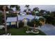 Twilight accentuates the home's lush landscaping and driveway, enhancing the home's curb appeal at 403 75Th St, Holmes Beach, FL 34217