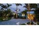 Twilight accentuates the home's lush landscaping and driveway, enhancing the home's curb appeal at 403 75Th St, Holmes Beach, FL 34217