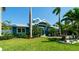 Charming blue home boasts lush landscaping and a well-manicured lawn, creating a welcoming curb appeal at 403 75Th St, Holmes Beach, FL 34217