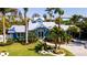 Charming blue home boasts lush landscaping and a well-manicured lawn, creating a welcoming curb appeal at 403 75Th St, Holmes Beach, FL 34217