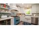 Charming kitchen with white cabinets, stainless steel appliances, a farmhouse sink, and a stylish blue range at 403 75Th St, Holmes Beach, FL 34217