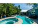 Relaxing backyard pool and patio area surrounded by lush, tropical landscaping at 403 75Th St, Holmes Beach, FL 34217