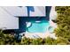 Aerial view of a private pool with spa, sun loungers, and lush tropical landscaping for ultimate relaxation at 403 75Th St, Holmes Beach, FL 34217