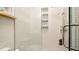 Bright shower featuring white wavy wall tile, niche shelving with decorative tile and a glass door at 403 75Th St, Holmes Beach, FL 34217