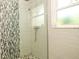 Elegant glass shower featuring sleek tile, shower window, and modern fixtures at 403 75Th St, Holmes Beach, FL 34217