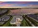 Stunning aerial view of a lakeside home showcasing manicured lawns and a tranquil waterfront setting at sunset at 508 Blue Shell Loop, Sarasota, FL 34240