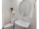 Chic powder room with a pedestal sink, round mirror, and elegant decor at 508 Blue Shell Loop, Sarasota, FL 34240