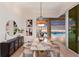 Stylish dining room with decorative lighting, a marble table, and views of the pool and waterfront at 508 Blue Shell Loop, Sarasota, FL 34240