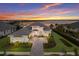 Beautiful new home showcasing lush landscaping and a paver driveway with an inviting exterior at dusk at 508 Blue Shell Loop, Sarasota, FL 34240