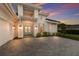 Beautiful home with a paved driveway and manicured lawn at dusk at 508 Blue Shell Loop, Sarasota, FL 34240