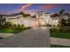 Striking curb appeal with an elegant home, three-car garage, and landscaped front yard at sunset at 508 Blue Shell Loop, Sarasota, FL 34240