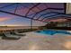 Enjoy the lake view relaxing on the loungers near the pool and spa inside of this screened enclosure at 508 Blue Shell Loop, Sarasota, FL 34240