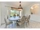 Dining room with decorative chandelier, large window view, and seating for six at 5168 Cillette Ave, North Port, FL 34288