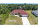 Aerial view of home with red roof, featuring a well-manicured lawn and driveway at 5168 Cillette Ave, North Port, FL 34288