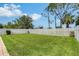 Spacious backyard featuring lush green grass, a white fence, and mature trees at 5238 Aqua Breeze Dr, Bradenton, FL 34208