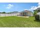 The backyard offers a well-maintained lawn, screened lanai, and a white fence, creating a private outdoor oasis at 5238 Aqua Breeze Dr, Bradenton, FL 34208